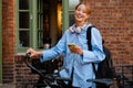 Young beautiful smiling woman in shirt with phone and bicycle Royalty Free Stock Photo