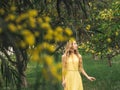 Young beautiful smiling woman in spring Australian Golden wattle trees.