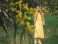 Young beautiful smiling woman in spring Australian Golden wattle trees.