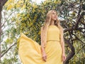 Young beautiful smiling woman in spring Australian Golden wattle trees.