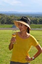A young beautiful smiling woman wearing a hat and holding a glass cold white wine Royalty Free Stock Photo