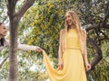 Young beautiful smiling women in spring Australian Golden wattle trees.