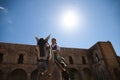 Young and beautiful Spanish woman riding on her brown horse, and wearing typical riding clothes. The woman has the sun on her back Royalty Free Stock Photo