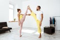 Young beautiful sportive couple training partner yoga asanas at home.