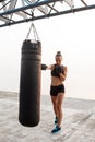 Young beautiful sportive girl training boxing at seaside.