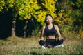 Young beautiful sports girl asian woman meditating in park, sitting lotus pose practicing yoga mat, zen. relaxes outdoors in Royalty Free Stock Photo