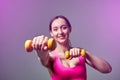 Young beautiful sports girl in leggings and a top does exercises with dumbbells. Healthy lifestyle. A woman goes in for sports at Royalty Free Stock Photo