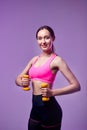 Young beautiful sports girl in leggings and a top does exercises with dumbbells. Healthy lifestyle. A woman goes in for sports at Royalty Free Stock Photo