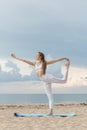 Young beautiful sportwoman practicing yoga in Natarajasana on sea background. Woman is making yoga on the beach Royalty Free Stock Photo