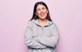 Young beautiful sporty woman wearing sportswear standing over isolated pink background happy face smiling with crossed arms Royalty Free Stock Photo