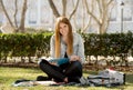 Young beautiful student girl on campus park grass with books studying happy preparing exam in education concept Royalty Free Stock Photo