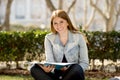 Young beautiful student girl on campus park grass with books studying happy preparing exam in education concept Royalty Free Stock Photo