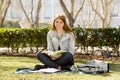 Young beautiful student girl on campus park grass with books studying happy preparing exam in education concept Royalty Free Stock Photo