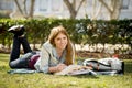 Young beautiful student girl on campus park grass with books studying happy preparing exam in education concept Royalty Free Stock Photo