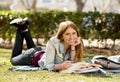 Young beautiful student girl on campus park grass with books studying happy preparing exam in education concept Royalty Free Stock Photo