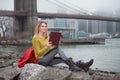 Young beautiful student girl reading a book sitting near New York City skyline Royalty Free Stock Photo