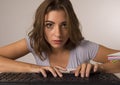 Young beautiful student girl or working woman typing on computer keyboard looking focused and concentrated in hard work Royalty Free Stock Photo