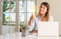 Young beautiful student woman with laptop at table, at home Royalty Free Stock Photo