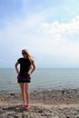 Young beautiful stylish girl in a simple black t-shirt posing near the sea Royalty Free Stock Photo