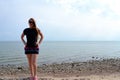 Young beautiful stylish girl in a simple black t-shirt posing near the sea Royalty Free Stock Photo