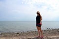 Young beautiful stylish girl in a simple black t-shirt posing near the sea Royalty Free Stock Photo