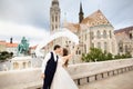 Young beautiful stylish pair of newlyweds kissing by the Fisherman`s Bastion in Budapest, Hungary
