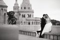 Young beautiful stylish pair of newlyweds sitting by the Fisherman`s Bastion in Budapest, Hungary. Black and white