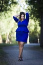 Young beautiful stylish plus size fashion model in blue dress outdoors, xxl woman on nature Royalty Free Stock Photo