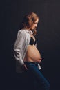 Young beautiful stylish pregnant woman posing in black underwear. Royalty Free Stock Photo