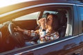 Young beautiful stylish woman driving her new car and drinking coffee on a sunny day. Concept for car rental Royalty Free Stock Photo