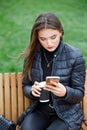 Young beautiful woman using smartphone in the park Royalty Free Stock Photo