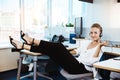 Young beautiful successful businesswoman resting, relaxing at workplace, over office background. Royalty Free Stock Photo