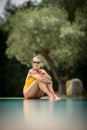 Young Beautiful Suntanned Woman relaxing next to a Swimming Pool Royalty Free Stock Photo
