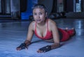 Young beautiful sweaty Asian woman in sport clothes stretching on gym dojo floor smiling posing corporate in hard training workout