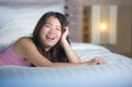 Young beautiful and sweet Asian Chinese woman lying playful and comfortable in bed relaxed and happy at her cozy bedroom smiling c Royalty Free Stock Photo