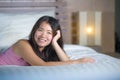 Young beautiful and sweet Asian Chinese woman lying playful and comfortable in bed relaxed and happy at her cozy bedroom smiling c Royalty Free Stock Photo