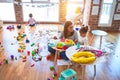 Young beautiful teacher and toddlers playing on the table with lots of toys at kindergarten Royalty Free Stock Photo