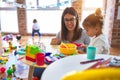 Young beautiful teacher and toddlers playing on the table with lots of toys at kindergarten Royalty Free Stock Photo