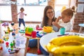 Young beautiful teacher and toddlers playing on the table with lots of toys at kindergarten Royalty Free Stock Photo