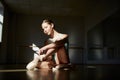 Young beautiful teen girl, classical ballet dancer getting ready to train in ballet school on a day with sunlight Royalty Free Stock Photo