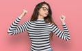 Young beautiful teen girl wearing casual clothes and glasses showing arms muscles smiling proud Royalty Free Stock Photo