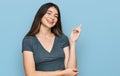 Young beautiful teen girl wearing casual crop top t shirt with a big smile on face, pointing with hand and finger to the side Royalty Free Stock Photo