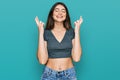 Young beautiful teen girl wearing casual crop top t shirt gesturing finger crossed smiling with hope and eyes closed Royalty Free Stock Photo