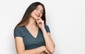 Young beautiful teen girl wearing casual crop top t shirt looking confident at the camera with smile with crossed arms and hand Royalty Free Stock Photo