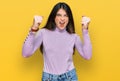 Young beautiful teen girl wearing turtleneck sweater angry and mad raising fists frustrated and furious while shouting with anger Royalty Free Stock Photo
