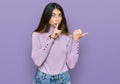 Young beautiful teen girl wearing turtleneck sweater asking to be quiet with finger on lips pointing with hand to the side Royalty Free Stock Photo