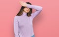 Young beautiful teen girl wearing turtleneck sweater covering eyes with arm, looking serious and sad Royalty Free Stock Photo