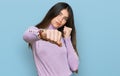 Young beautiful teen girl wearing turtleneck sweater punching fist to fight, aggressive and angry attack, threat and violence Royalty Free Stock Photo