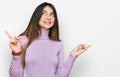 Young beautiful teen girl wearing turtleneck sweater smiling confident pointing with fingers to different directions Royalty Free Stock Photo