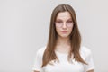 Young beautiful teen girl wearing white t shirt and glasses over white background Relaxed with serious expression on face. Simple Royalty Free Stock Photo